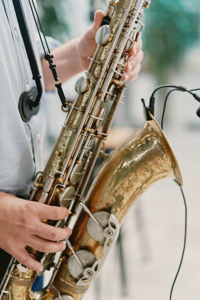 Saxophonist plays the saxophone on stage. Cropped